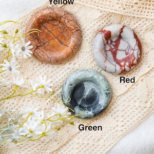 May include: Three circular stone dishes labeled Yellow, Red, and Green. The Yellow dish has a brown, cracked texture. The Red dish features white and red marbled patterns. The Green dish displays dark green and black swirling stone textures.