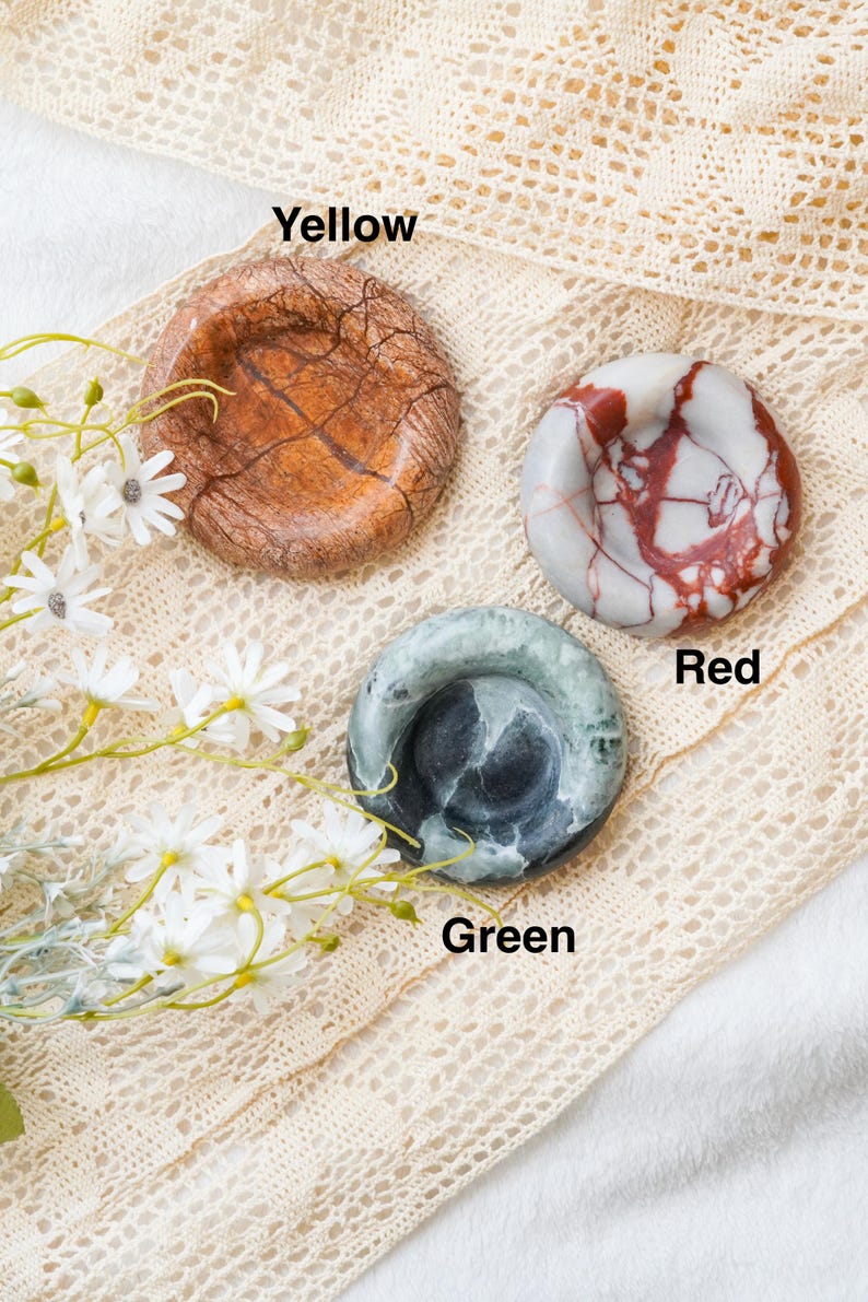 May include: Three circular stone dishes labeled Yellow, Red, and Green. The Yellow dish has a brown, cracked texture. The Red dish features white and red marbled patterns. The Green dish displays dark green and black swirling stone textures.