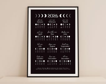 May include: A framed black and white 2026 calendar print. The calendar displays the phases of the moon for each month, with the month names and dates listed below. The print is in a black frame.
