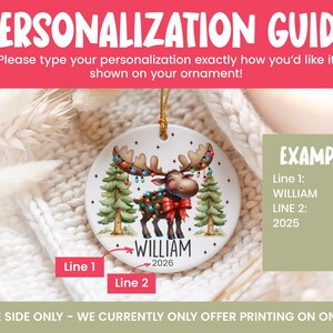 Op de afbeelding: Een rond wit keramieken ornament met een cartoon-eland met kerstverlichting in het gewei en op het lichaam, geflankeerd door twee dennenbomen. De tekst luidt WILLIAM en 2026. Een gids toont voorbeelden voor de personalisatie van de tekst.