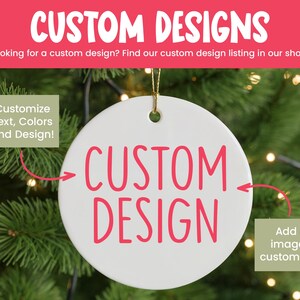 Op de afbeelding: Een rond wit keramieken ornament met de roze tekst CUSTOM DESIGN in het midden. Het ornament heeft een klein gaatje aan de bovenkant met een gouden touwtje. Tekst op de afbeelding bevat CUSTOM DESIGNS, Customize Text, Colors and Design! en Add an image or custom logo!