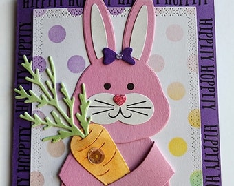 Easter card with a cute pink bunny holding a carrot and polka dots in the background.