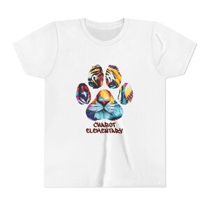 May include: White t-shirt featuring a colorful paw print design with a tiger face in the center. The text "CHABOT ELEMENTARY" is printed below the paw print in a brown font. The shirt is made of a soft material.