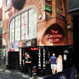 Puede incluir: The Cavern Club en Liverpool, Inglaterra, es un famoso local de música. El letrero sobre la entrada dice "The Cavern Club".