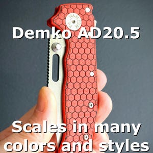 May include: A red and silver folding knife with a honeycomb pattern on the handle. The text "Demko AD20.5" and "Scales in many colors and styles" are displayed on the image. The knife is held in a hand.