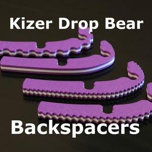 May include: Three purple and white foam keyboard backspacers with the text "Kizer Drop Bear Backspacers" on a black surface.