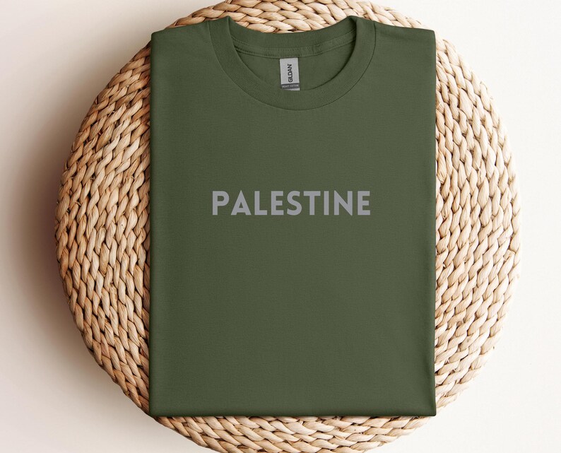 May include: A green t-shirt with the word "PALESTINE" printed in white on the front.