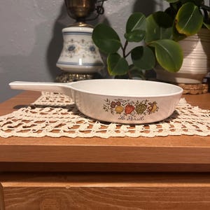 May include: A set of three ceramic mugs with a speckled, matte finish. The mugs are in shades of cream, light gray, and dark gray. Each mug has a simple, minimalist design and a rounded handle. The mugs are stacked on top of each other.