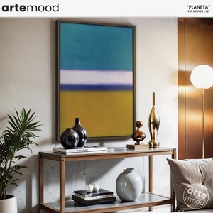 May include: A framed abstract painting with horizontal bands of teal, white, purple, and yellow. The painting is hanging on a wall above a wooden console table with two black ceramic vases, a gold metal vase, and a copper-colored decorative object. The table has a glass top and a book titled "Vogue 1950-1980" on it. The console table is in front of a white wall.