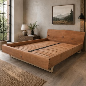 Pode incluir: Uma estrutura de cama de plataforma baixa feita de madeira castanho-clara com uma cabeceira de borda natural. A cama possui uma base de ripas com uma cinta de suporte central e é apoiada por pernas de metal de cor clara nos cantos.