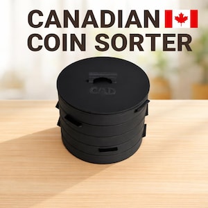Puede incluir: Un clasificador de monedas canadiense cilíndrico de color negro con diseño apilable y una tapa con el texto CAD. El dispositivo tiene pequeñas asas laterales y un asa central superior, con el texto CANADIAN COIN SORTER y una bandera encima.