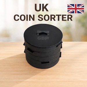 May include: A black cylindrical UK coin sorter with a stackable design. The top lid features a small handle and the text GBP embossed in the centre. The device is composed of multiple circular tiers, each with a small slot on the side for sorting coins.