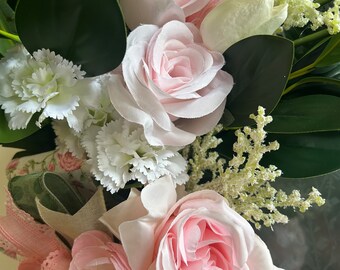 Delicate, baby pink roses nestled perfectly amongst velvety soft tulips and bright white carnations.