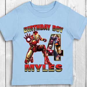 Może przedstawiać: Jasnoniebieska koszulka z grafiką Iron Mana w kolorze czerwonym i złotym, cyfrą 4 i tekstem "Birthday Boy Myles".