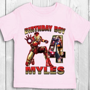 Może przedstawiać: R&oacute;żowa koszulka z grafiką Iron Mana i cyfrą 4. Na koszulce nadrukowany jest tekst "Birthday Boy" i "Myles".