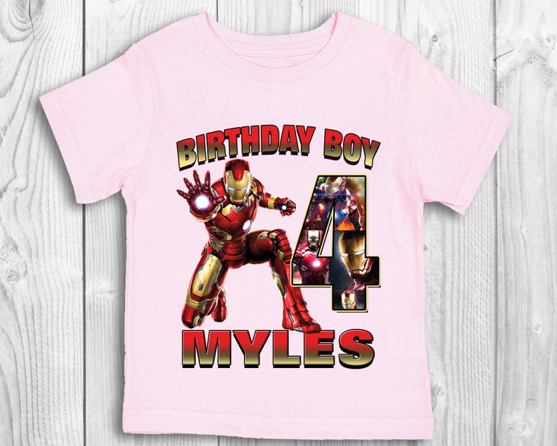 Może przedstawiać: R&oacute;żowa koszulka z grafiką Iron Mana i cyfrą 4. Na koszulce nadrukowany jest tekst "Birthday Boy" i "Myles".