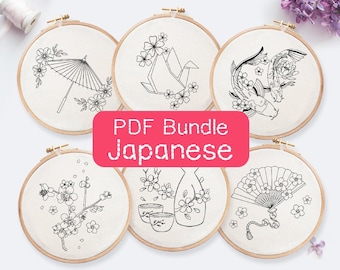 May include: A set of six embroidery patterns featuring Japanese-inspired designs. The patterns include a cherry blossom branch, a fan, a sake bottle, a koi fish, a paper crane, and an umbrella.