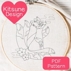 Puede incluir: Patrón de bordado de línea de un kitsune, un zorro mítico japonés con nueve colas, sentado con la cabeza inclinada hacia arriba. El patrón incluye nubes y flores de cerezo. El texto "PDF Pattern" está en un rectángulo rosa en la parte inferior de la imagen.
