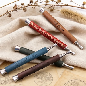 May include: A selection of personalised cigar accessories. The collection features brown, red, blue, and green leather-wrapped cigar tools with silver accents. Some tools have text that reads "Oliver", "The best father", and "Sofia & William".