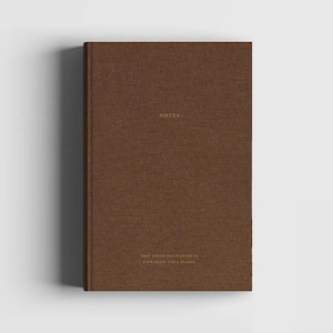 May include: A brown linen-covered notebook with the word "NOTES" printed in gold on the front cover. The back cover has the text "That dream was planted in your heart for a reason."