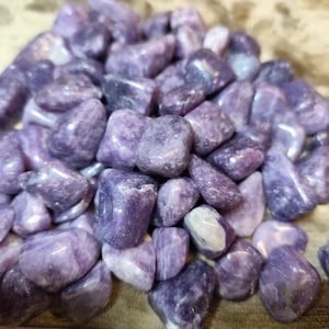 Peut inclure: Un tas de pierres roulées de couleur violette, allant du lavande clair au violet foncé. Les pierres ont un aspect lisse et poli, avec des variations de couleur et de texture. L'ensemble est un ensemble d'éléments naturels et décoratifs.