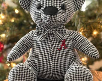 Könnte beinhalten: Ein schwarz-weiß karierter Teddybär mit schwarzer Fliege und einem roten gestickten Buchstaben "A".