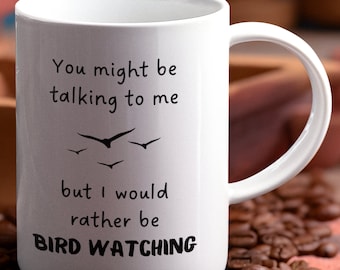May include: White ceramic mug with black text that reads "You might be talking to me but I would rather be BIRD WATCHING". There are four black silhouettes of birds flying above the text.