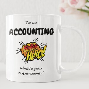 Può includere: Tazza da caffè in ceramica bianca con una grafica in bianco e nero che dice "Sono un supereroe della contabilità! Qual è il tuo superpotere?"