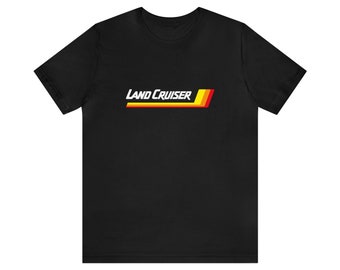Könnte beinhalten: Schwarzes T-Shirt mit dem weißen Schriftzug "LAND CRUISER" und einem horizontalen Streifendesign in Gelb, Rot und Orange. Das T-Shirt hat einen Rundhalsausschnitt und kurze Ärmel.