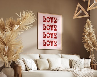 May include: A framed print with the word "LOVE" repeated four times in a bold, red font on a light pink background. The print is hanging on a brown wall above a beige couch with pillows.