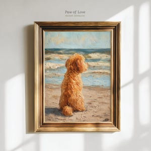 Puede incluir: Pintura al óleo enmarcada que representa a un perro dorado sentado en una playa de arena, mirando al océano. La obra de arte presenta un marco dorado y el texto "Paw of Love - Instant Download" en la parte superior.