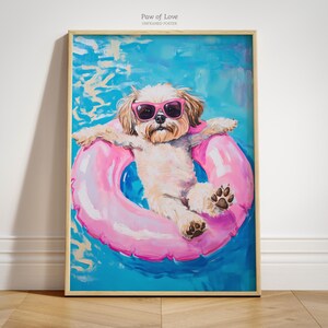 May include: A framed print titled "Paw of Love" depicts a dog wearing pink sunglasses, relaxing in a pink inflatable ring in a pool. The dog has light brown fur and is set against a blue background. The artwork is unframed.