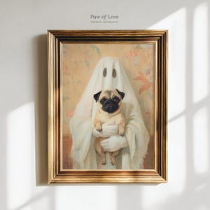 Puede incluir: Una lámina enmarcada titulada Paw of Love Instant Download con la pintura de una figura cubierta por una sábana de fantasma blanca que sostiene un perro pug beige y negro. La obra tiene un fondo color melocotón y un marco dorado.