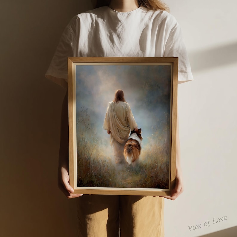 May include: A framed print depicts a figure in a white robe walking with a dog through a field. The artwork has a soft, ethereal quality with muted colors and a focus on light and shadow. The dog has brown and white fur.