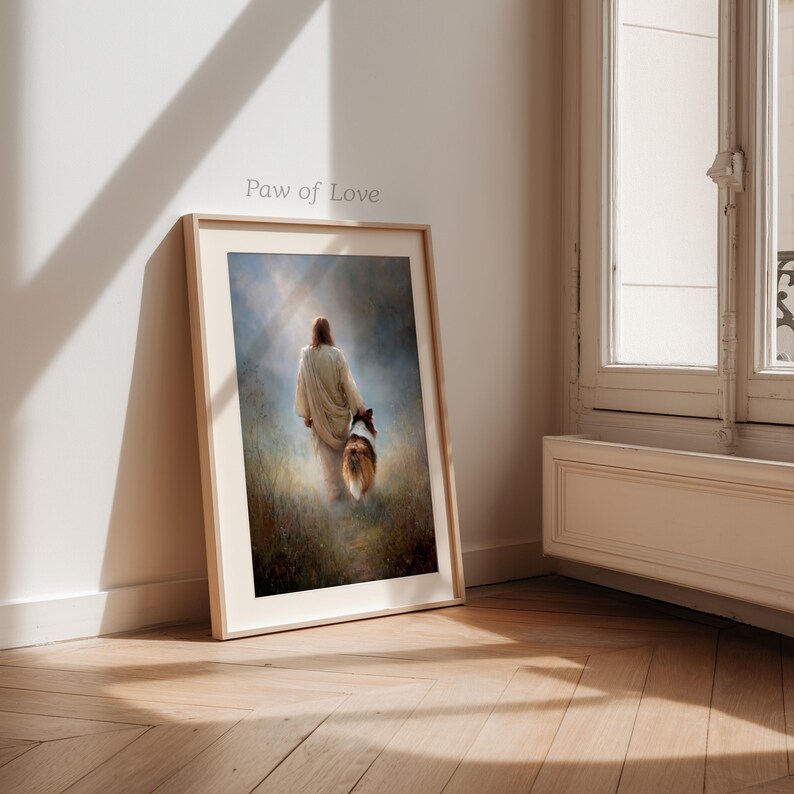 May include: Framed art print featuring a person in a white robe walking with a dog through a field. The artwork has a soft, ethereal quality with a warm color palette. The text "Paw of Love" is visible on the frame.