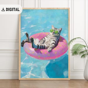 Op de afbeelding: Digitale print van een kat met een zonnebril, ontspannen op een roze opblaasbare ring in een zwembad. De kat heeft grijs en zwarte strepen. De achtergrond is een lichtblauw zwembad met waterreflecties. De print zit in een houten lijst.