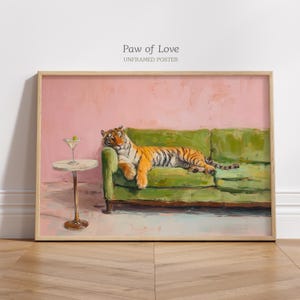 Può includere: Un poster rettangolare senza cornice intitolato Paw of Love che presenta un dipinto a olio di una tigre arancione e nera sdraiata su un divano verde accanto a un tavolino rotondo con un bicchiere da martini contenente un'oliva verde su muro rosa.