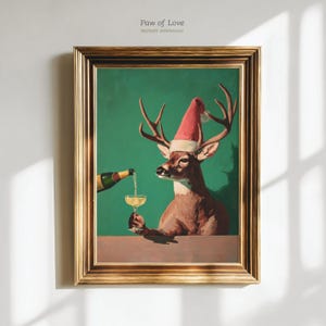 Könnte beinhalten: Gerahmter Kunstdruck mit einem Hirsch mit Weihnachtsmütze, der ein Champagnerglas hält, in das Champagner gegossen wird. Das Kunstwerk hat einen grünen Hintergrund und einen goldenen Rahmen. Der Text "Paw of Love" ist oben.