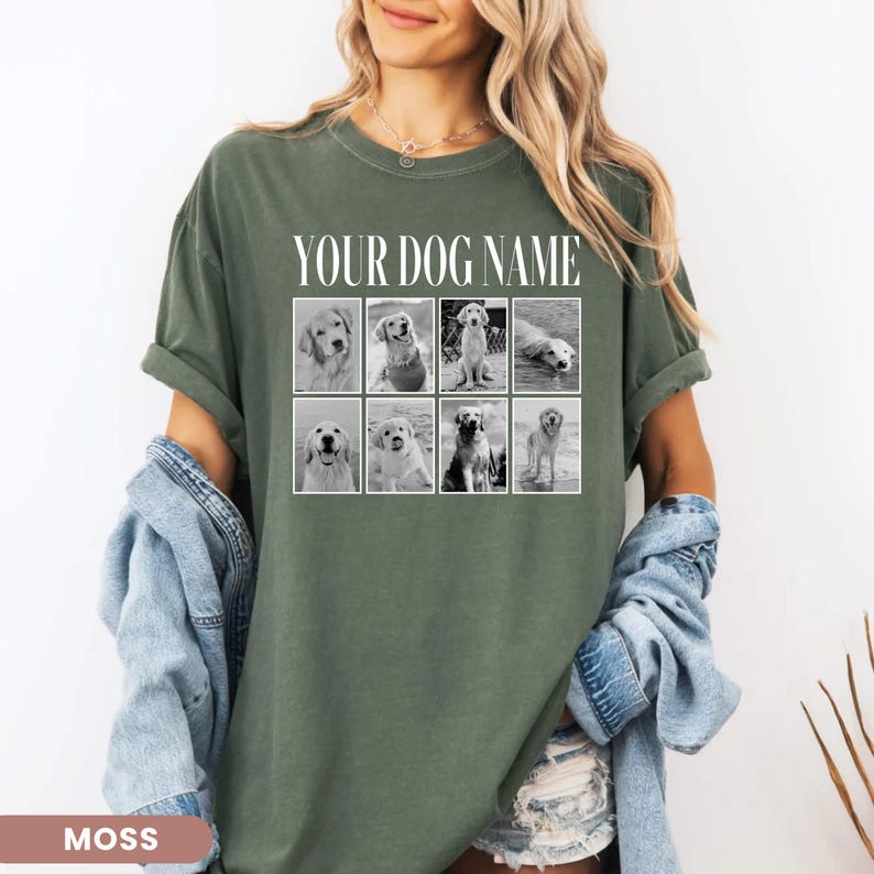 May include: A moss green short-sleeve t-shirt featuring the white text YOUR DOG NAME above a grid of eight black and white photographs of dogs. The shirt has a crew neckline and a relaxed fit, with a denim jacket draped over the arms.