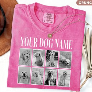 May include: A bright pink short-sleeved t-shirt featuring the text YOUR DOG NAME in white capital letters above a grid of eight black and white photographs of dogs. The shirt has a crew neckline and a Comfort Colors brand label on the inside collar.