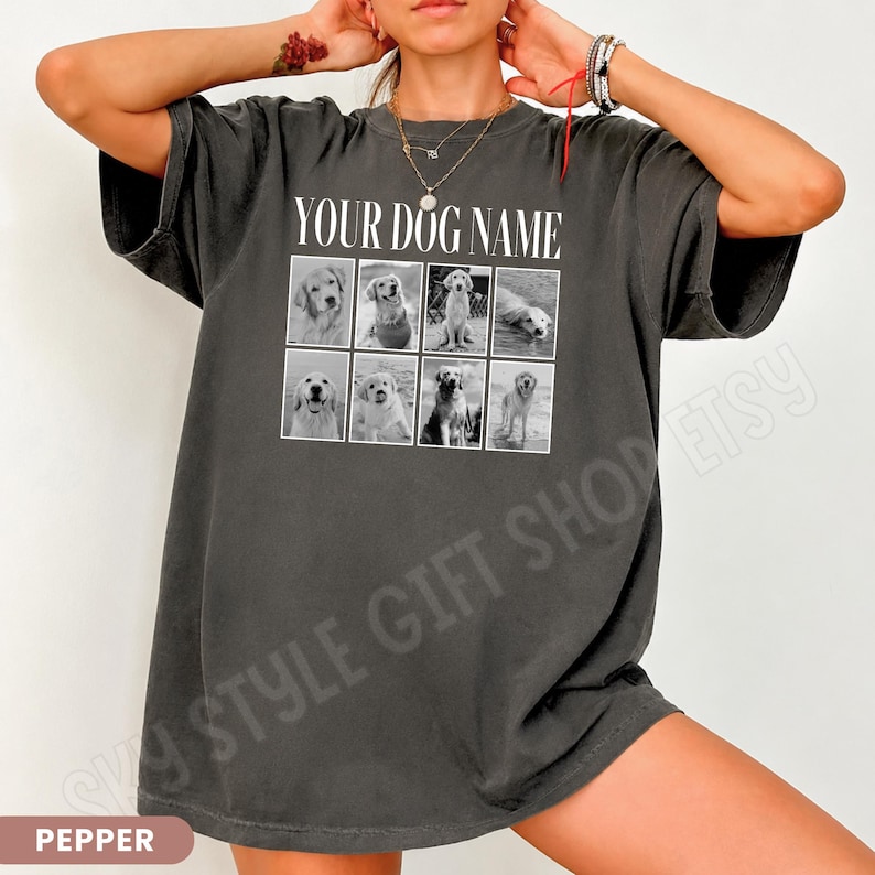 May include: A charcoal grey short-sleeved t-shirt featuring the white text YOUR DOG NAME above a grid of eight black and white photographs of golden retriever dogs in various poses, including sitting, standing, and swimming in water.