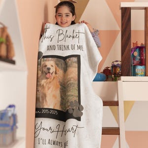 May include: White blanket featuring a photo of a golden retriever dog with the text "This Blanket and Think of Me" and "Your Heart I'll Always Be". The blanket includes the years 2015-2025 and paw prints.