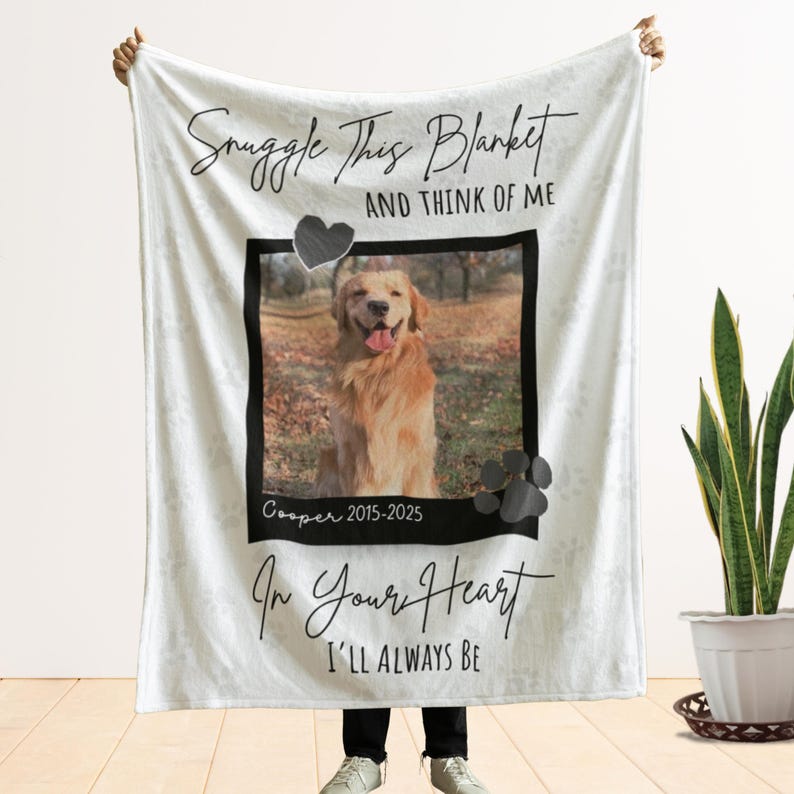 May include: White blanket with a photo of a golden retriever dog, a black heart, and paw prints. The blanket has the text "Snuggle This Blanket And Think Of Me" and "In Your Heart I'll Always Be". The dog's name and dates are also printed on the blanket.