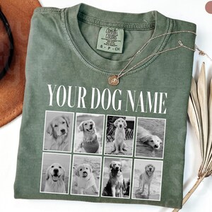 May include: A moss green t-shirt featuring the white text "YOUR DOG NAME" above a grid of eight black and white photographs of dogs. The shirt has a crew neckline and a Comfort Colors brand label on the inside collar.