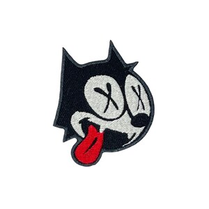May include: Black and white cartoon cat with a red tongue sticking out. The cat has X's for eyes and a mischievous expression.