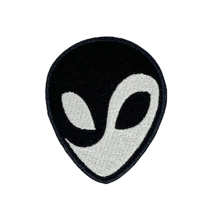 Könnte beinhalten: Schwarzer und weißer gestickter Alien-Kopf-Patch mit Yin-Yang-Design.