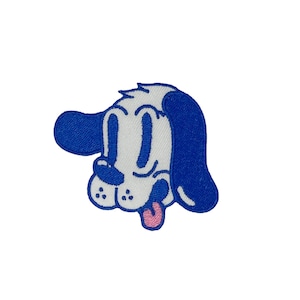 May include: A white cartoon dog with blue ears and a pink tongue sticking out. The dog has large eyes and a simple, stylized design.