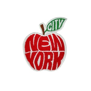 Könnte beinhalten: Gestickter Aufnäher in Form eines roten Apfels mit den weißen Worten "NEW YORK". Ein grünes Blatt mit dem Wort "CITY" ist oben angebracht. Der Aufnäher hat einen weißen Rand und einen braunen Stiel.