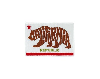 May include: A white patch with a red star in the top left corner. The patch features a brown bear silhouette made up of the word "CALIFORNIA" and the text "REPUBLIC" in green below the bear.