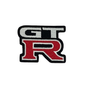 Peut inclure: Un patch brodé noir et blanc avec les lettres "GT" en blanc et la lettre "R" en rouge.